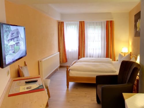 Helles Zimmer mit TV, Schreibtisch und Sessel