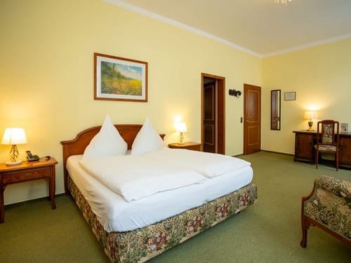 Großes Hotelzimmer mit einem Schreibtisch und Sitzmöglichkeiten
