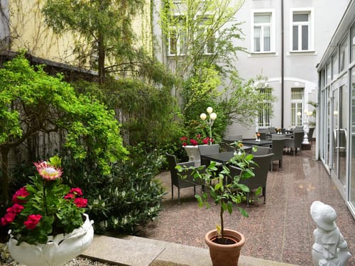 Hotelterrasse mit mehreren Tischen und Stühlen