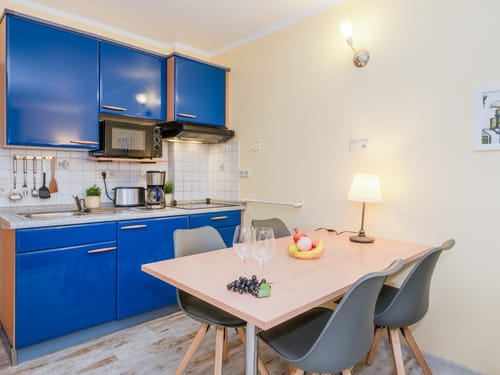 Moderne Küchenzeile mit blauen Schränken und Essbereich