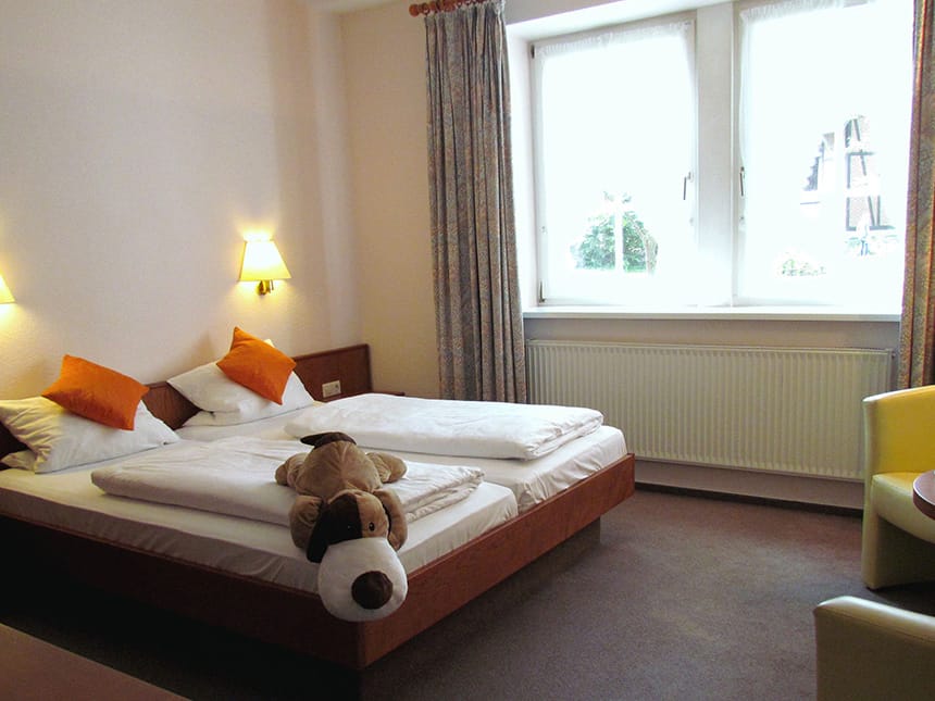 Doppelzimmer mit Doppelbett, zwei Sessel und Tisch