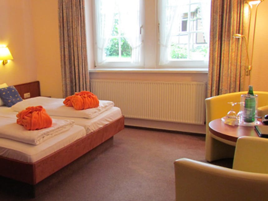 Doppelzimmer mit Doppelbett, Sesseln und Tisch