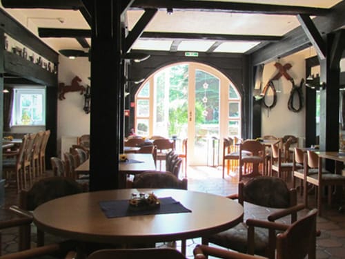 rustikale Hotelstube mit verschiedenen Tischgruppen