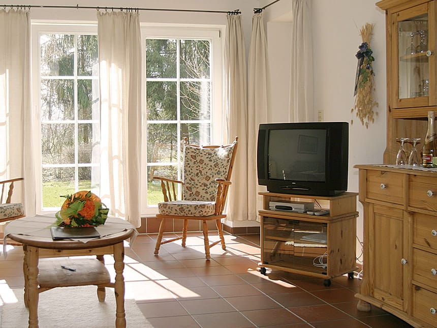 TV, Tisch mit Stühlen und ein Schrank