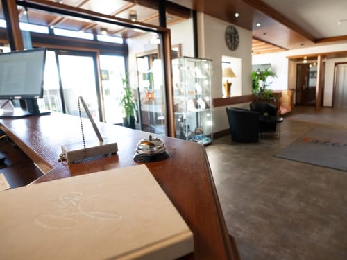 Hotelrezeption mit Klingel und Computer am Empfangstresen