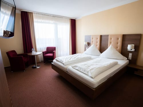 Gemütliches Hotelzimmer mit Doppelbett und Sitzbereich