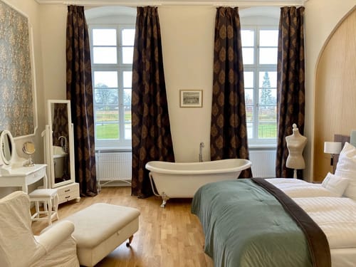 exklusive Ausstattung mit Boxspringbett, Kosmetikspiegel und Badewanne im Zimmer