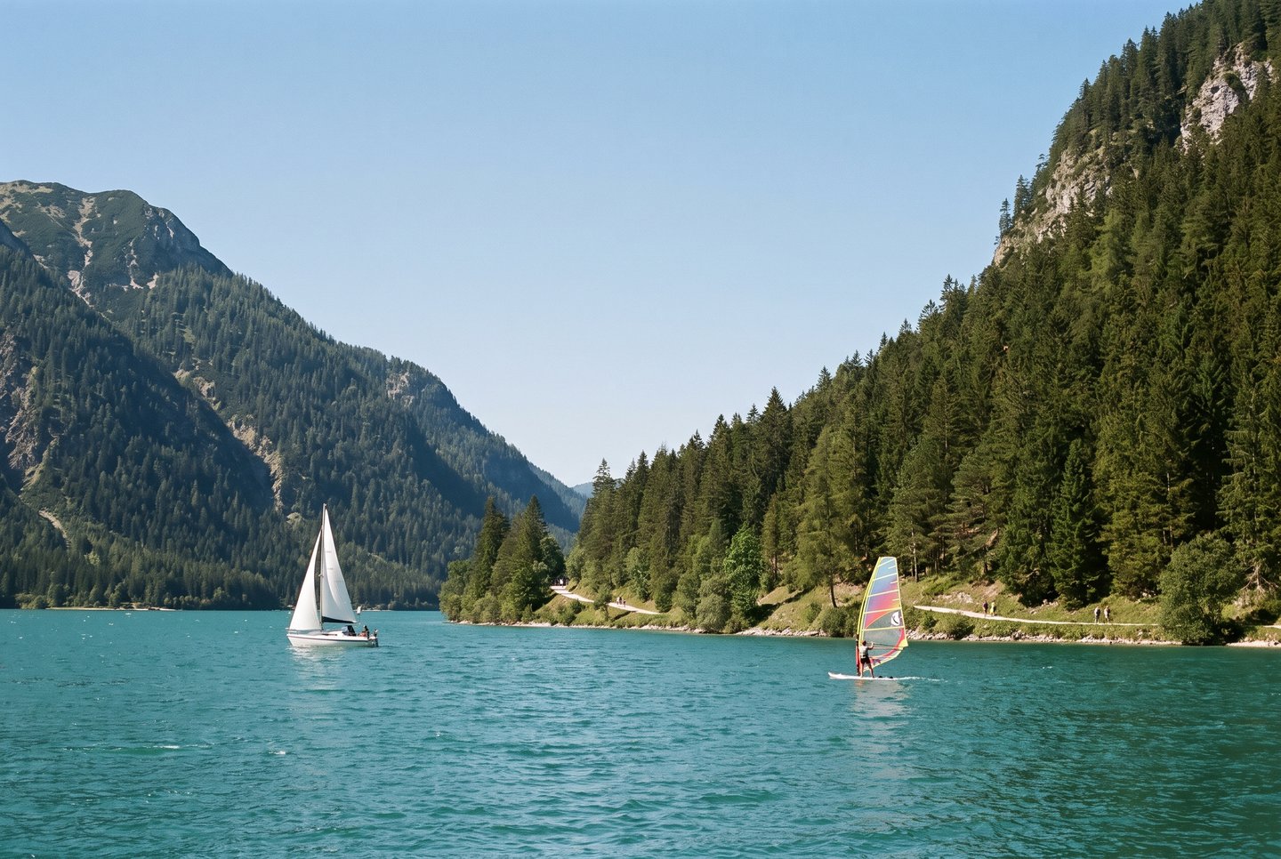 Achensee – Segeln und Wandern im Karwendelgebirge Segelboot und Windsurfer auf dem Achensee in Tirol vor der Kulisse des Karwendelgebirges