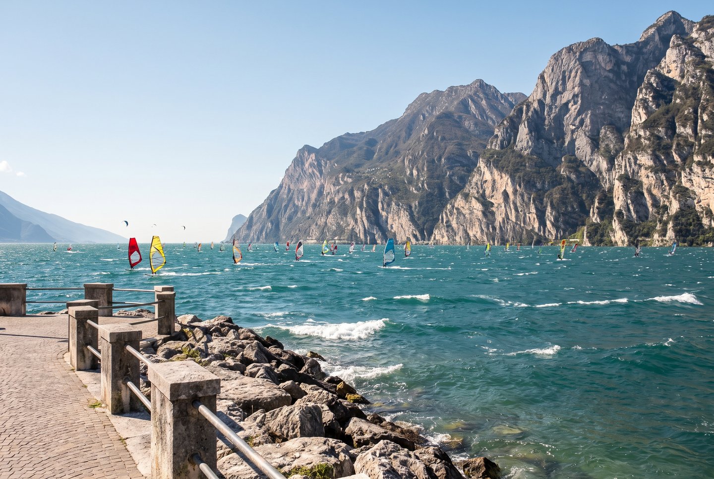 Windsurfer und Kitesurfer nutzen den Ora-Wind vor Torbole am Nordufer des Gardasees, Trentino