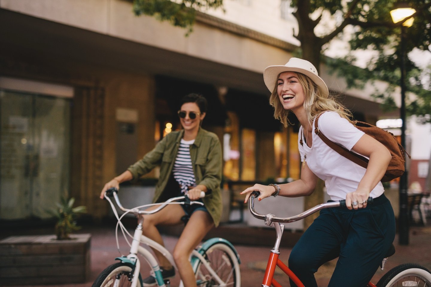 Freundinnen mit Fahrrädern bei einer Stadtfahrt im Wellnessurlaub – aktive Entspannung und gemeinsame Erlebnisse
