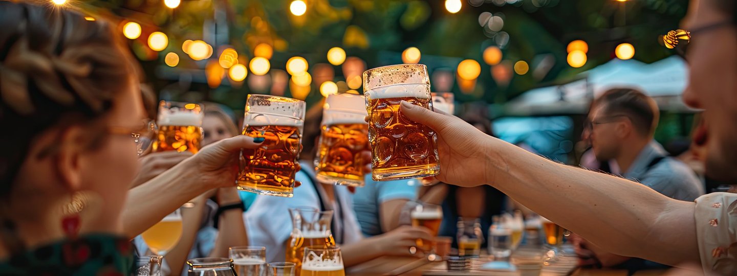 Anstoßen im Münchner Biergarten Freunde stoßen mit Maßkrügen im Münchner Biergarten an