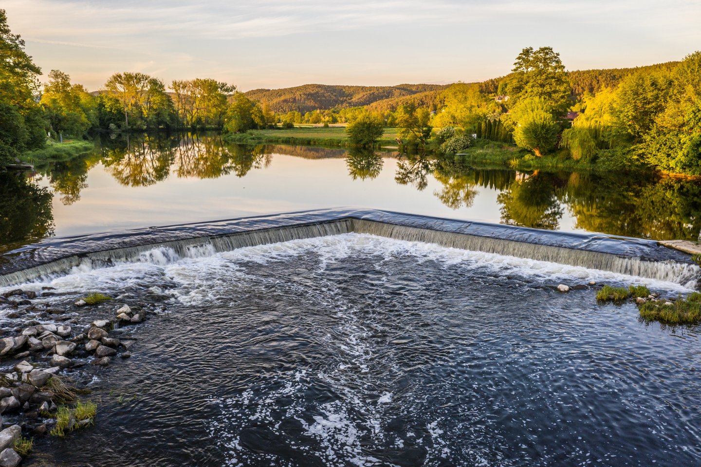Ruhige Flusslandschaft im Oberpfälzer Wald bei Sonnenuntergang – ideale Umgebung für abgeschiedene Wellnessrefugien.