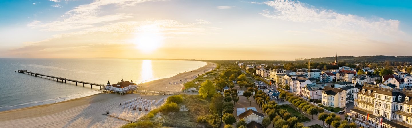 Seebrücke und Ostseebad im Panorama bei Sonnenaufgang – typischer Ostseeurlaubsort mit Bäderarchitektur