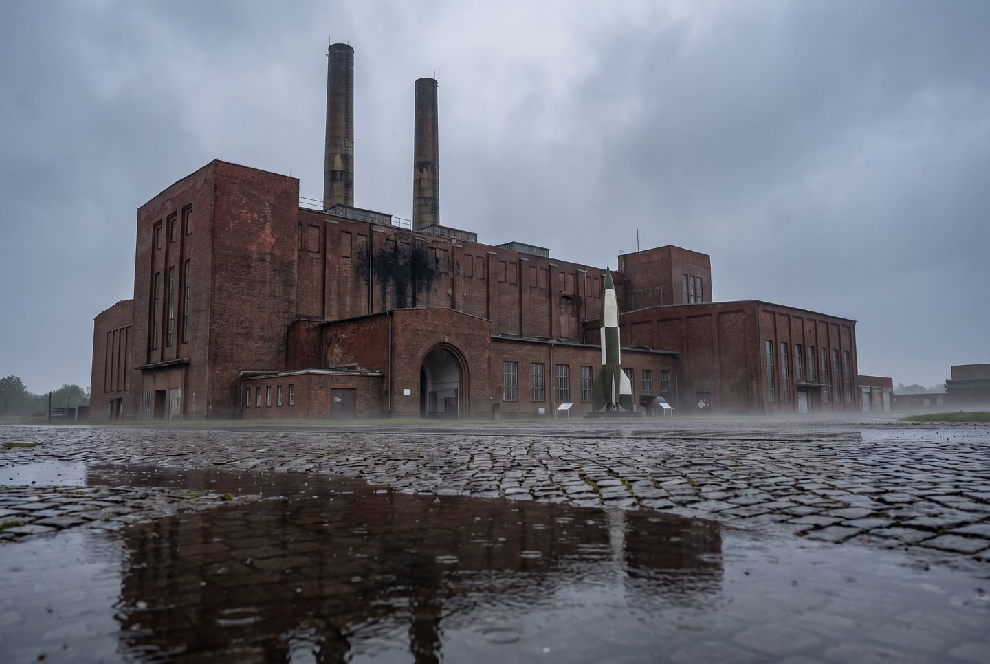 Peenemünde-Museum auf Usedom Historisches Kraftwerksgebäude des Peenemünde-Museums auf Usedom bei Regenwetter mit Raketen-Nachbau im Außenbereich