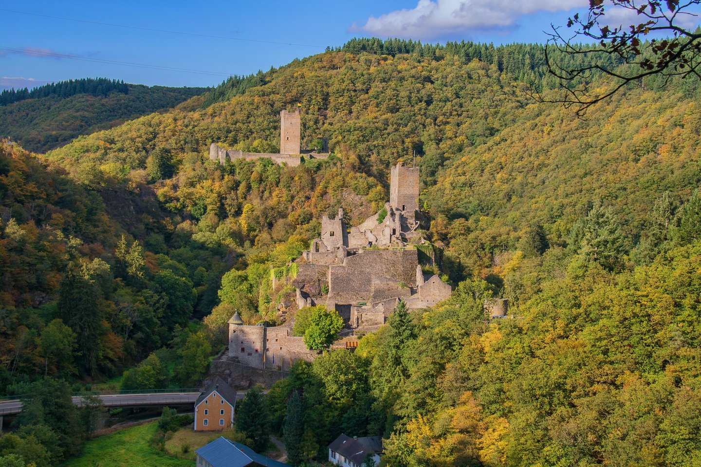 Burgruine inmitten der bewaldeten Hügellandschaft der Vulkaneifel – Wellnessurlaub mit historischem Flair.