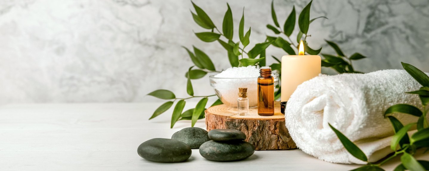 Wellness-Arrangement mit Massageölen, Kerzen und Hot Stones für Spa-Behandlungen
