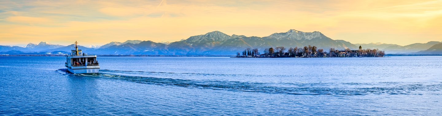 Panoramablick auf den Chiemsee bei Gstadt mit verschneiten Alpen im Hintergrund